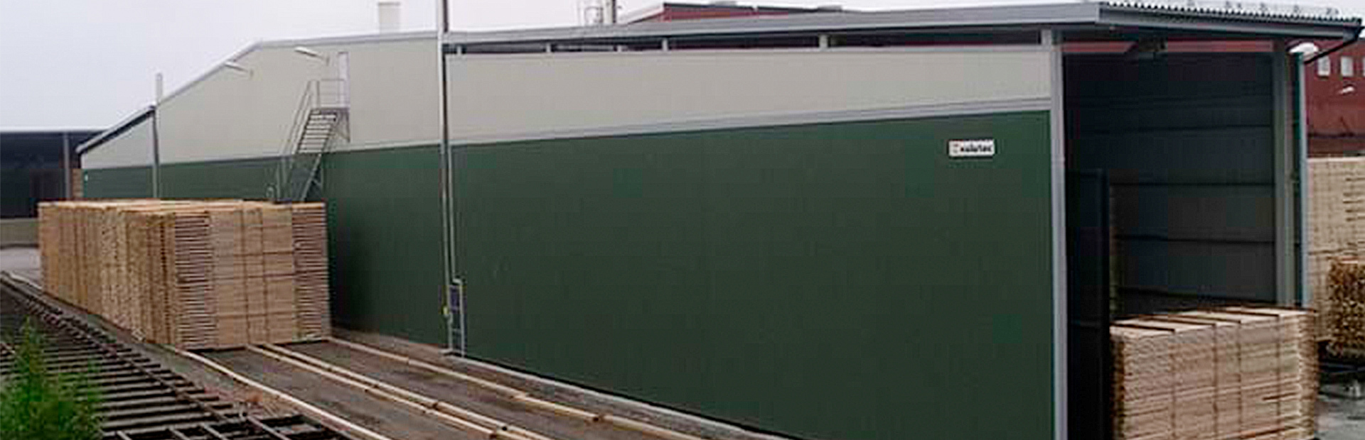 Grön Valutec kanaltork OTC med öppna portar, travar med virke synliga på in- och utsidan.