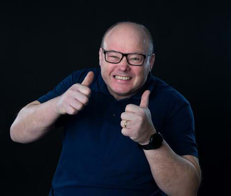 Valutecin Markku Hirvelä hymyilee ja näyttää peukkua molemmilla käsillä.