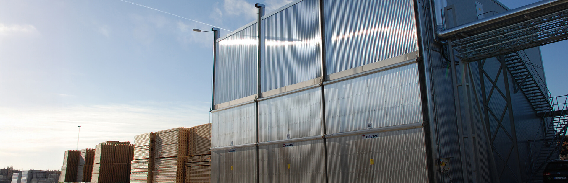 Truckmatad kammartork från Valutec med staplat virke utanför.